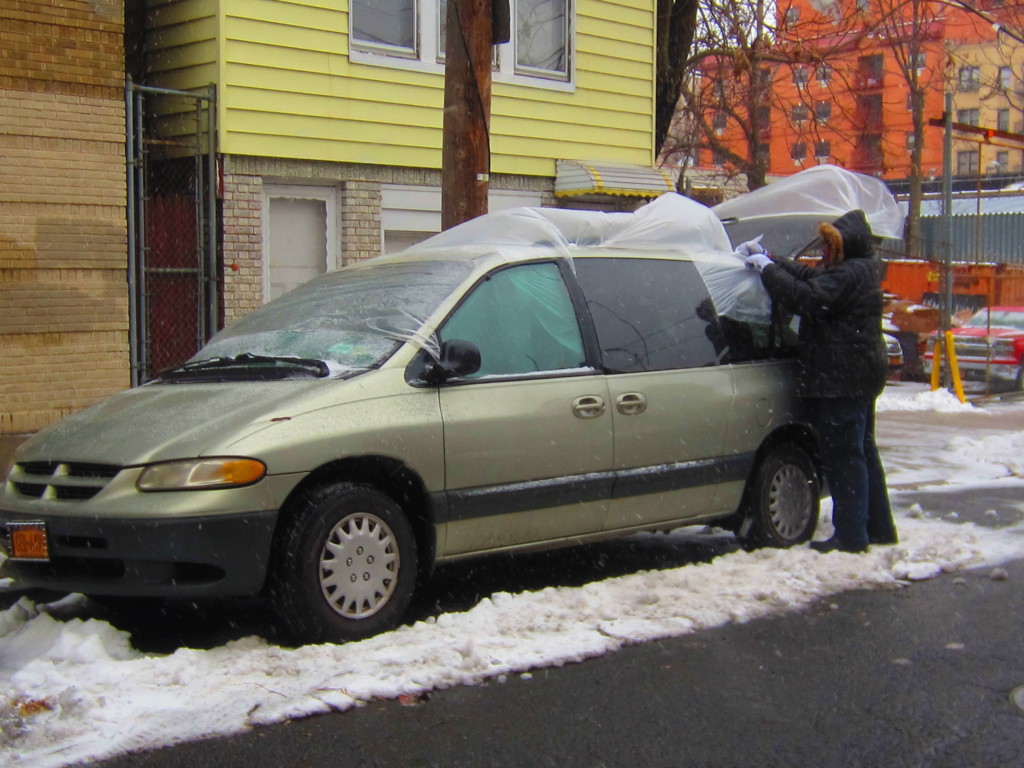 DONNETTA REID SEALS off her vehicle with sheets of plastic ahead of the major snowstorm of the year. Photo by David Cruz