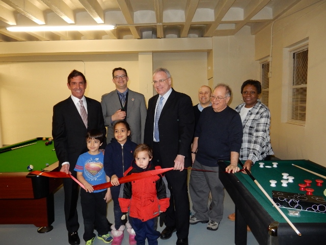 A NEW BOYS & GIRLS club is open at Amalgamated Houses in Van Cortlandt Village courtesy of MMCC, with officials and children standing behind the ceremonial red ribbon. Photo courtesy MMCC