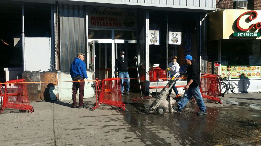 EMPLOYEES OF MORTON'S Supermarket debris caused by a two-alarm fire. Photo by Miriam Quinones